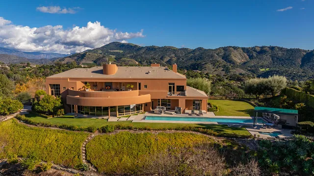 an aerial view of a house with swimming pool a patio and mountain view