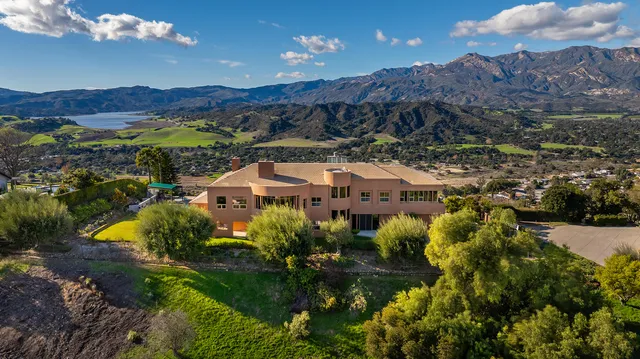an aerial view of house a garden and mountain view in back