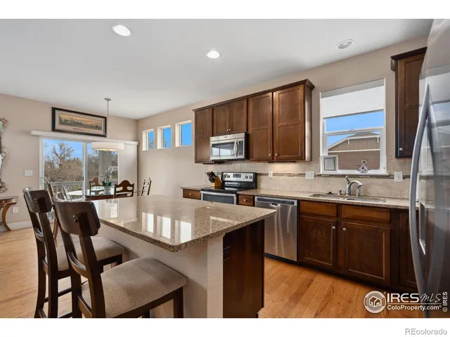 a kitchen with stainless steel appliances granite countertop a sink table and chairs