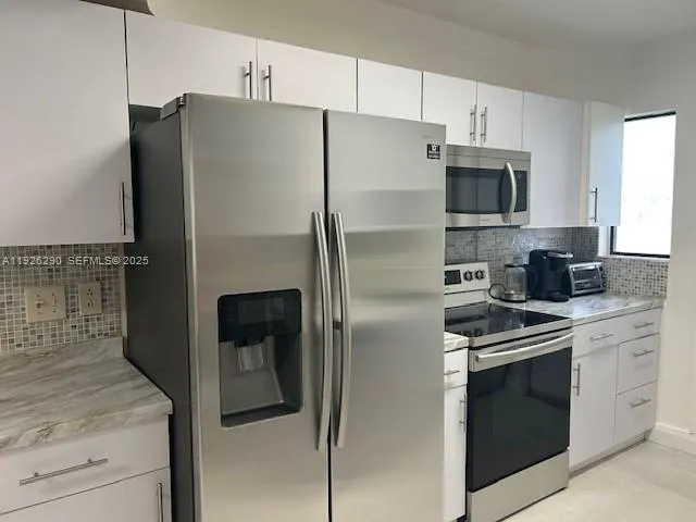 a kitchen with stainless steel appliances and refrigerator