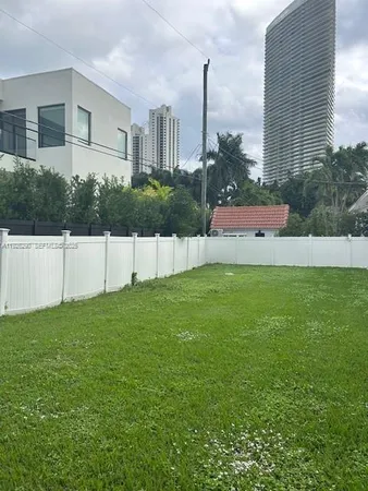 a view of a house with a yard and a fence