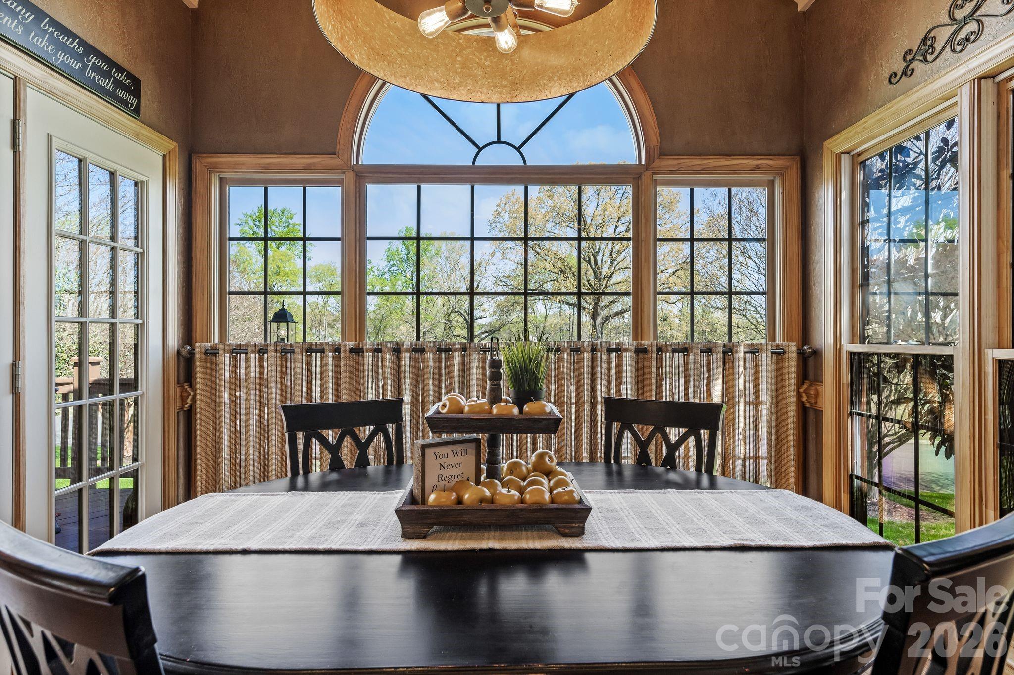 3530 Cardiff Lane Matthews, NC 28104 - Photo 18 of 39 a view of a dining room with furniture large windows and wooden floor