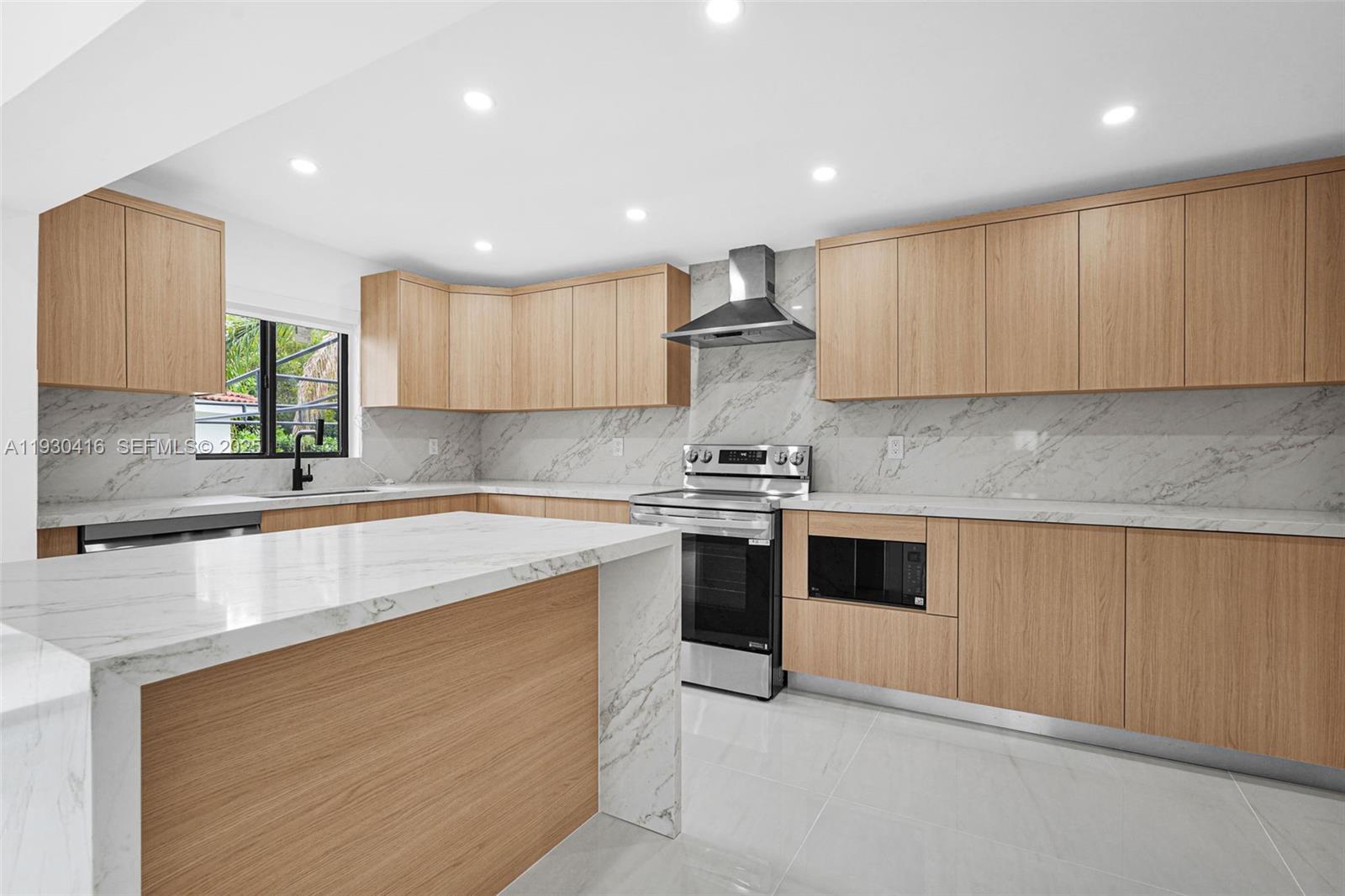 998 Southwest 11th Street Miami, FL 33129 - Photo 12 of 66 a kitchen with stainless steel appliances granite countertop a sink and a stove top oven