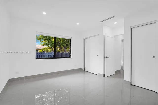 a front view of a house with a yard and an tree