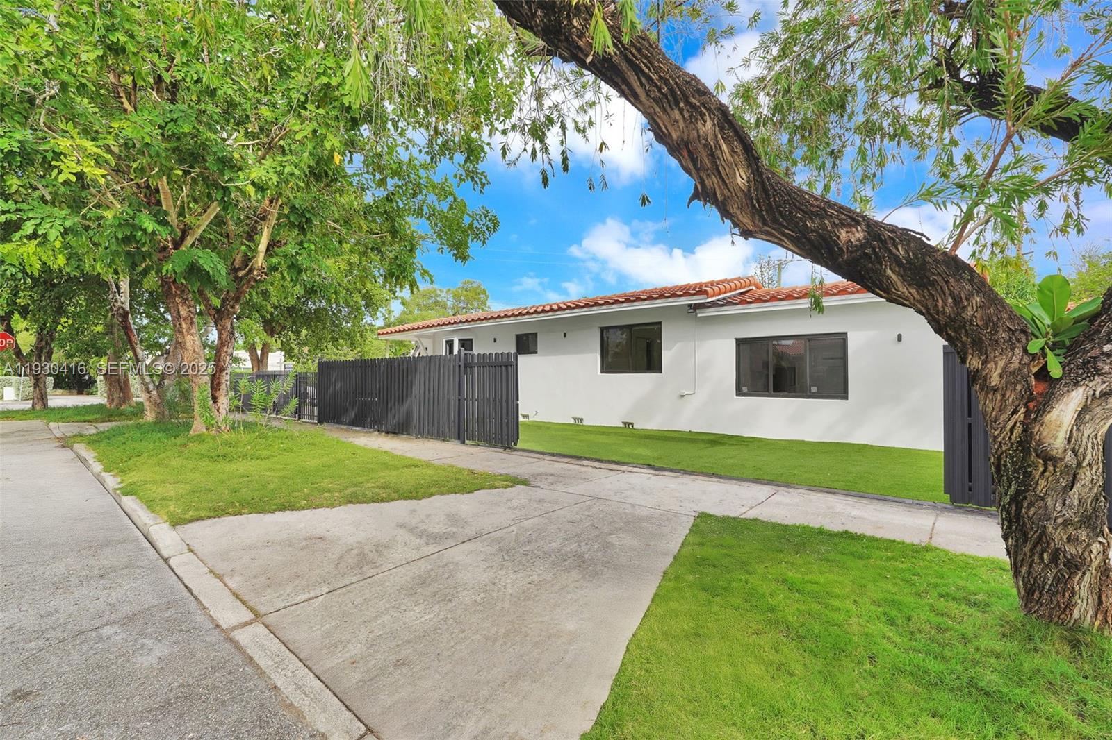 998 Southwest 11th Street Miami, FL 33129 - Photo 62 of 66 a view of a white house next to a yard with a large tree