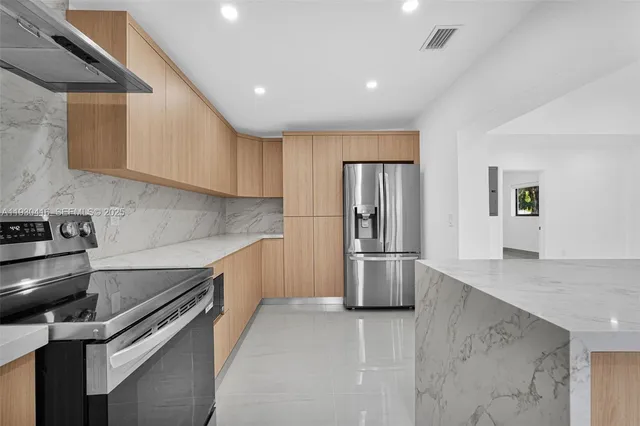 a kitchen with stainless steel appliances granite countertop a sink and a stove