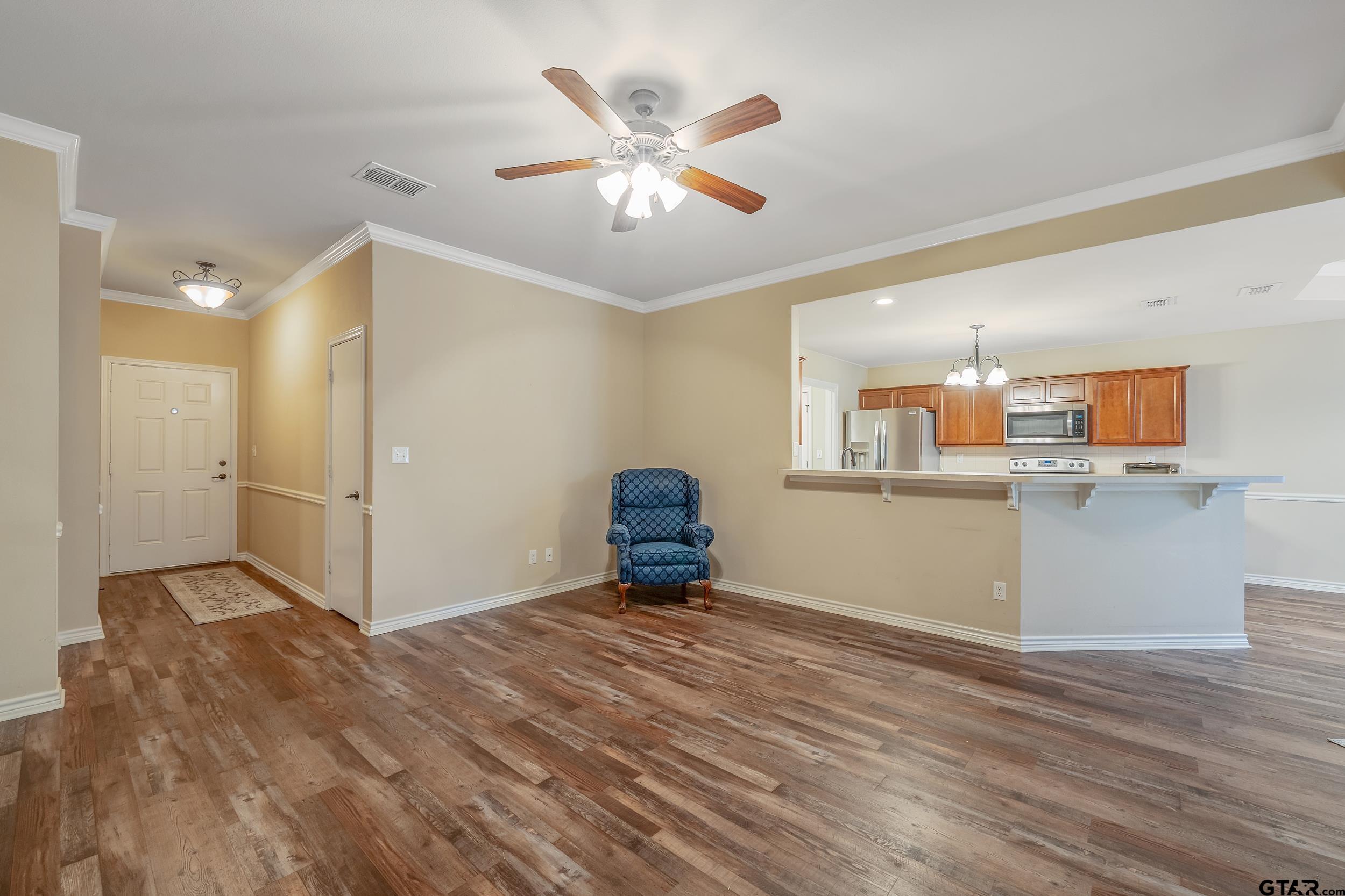 a view of a kitchen with wooden floor and a ceiling fan
