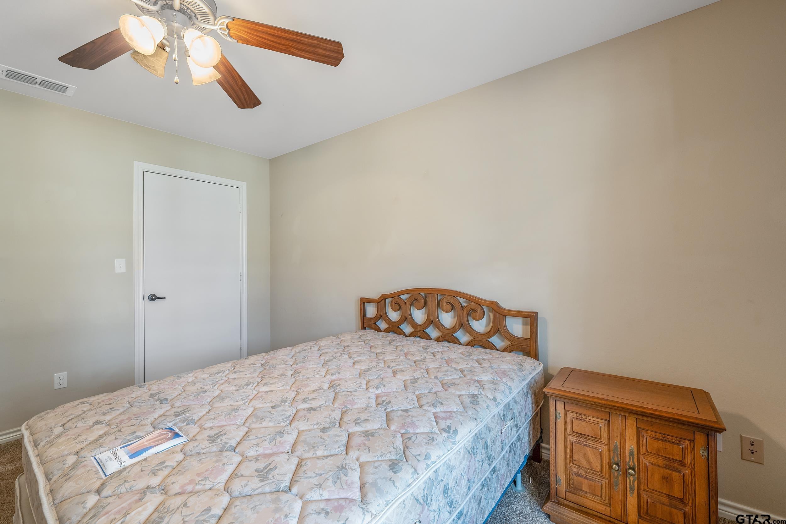 421 West Cumberland Road, Unit 205 Tyler, TX 75703 - Photo 12 of 24 a bedroom with a bed and a chandelier