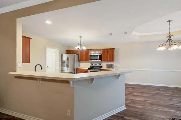a kitchen with stainless steel appliances a sink a stove and a wooden floors