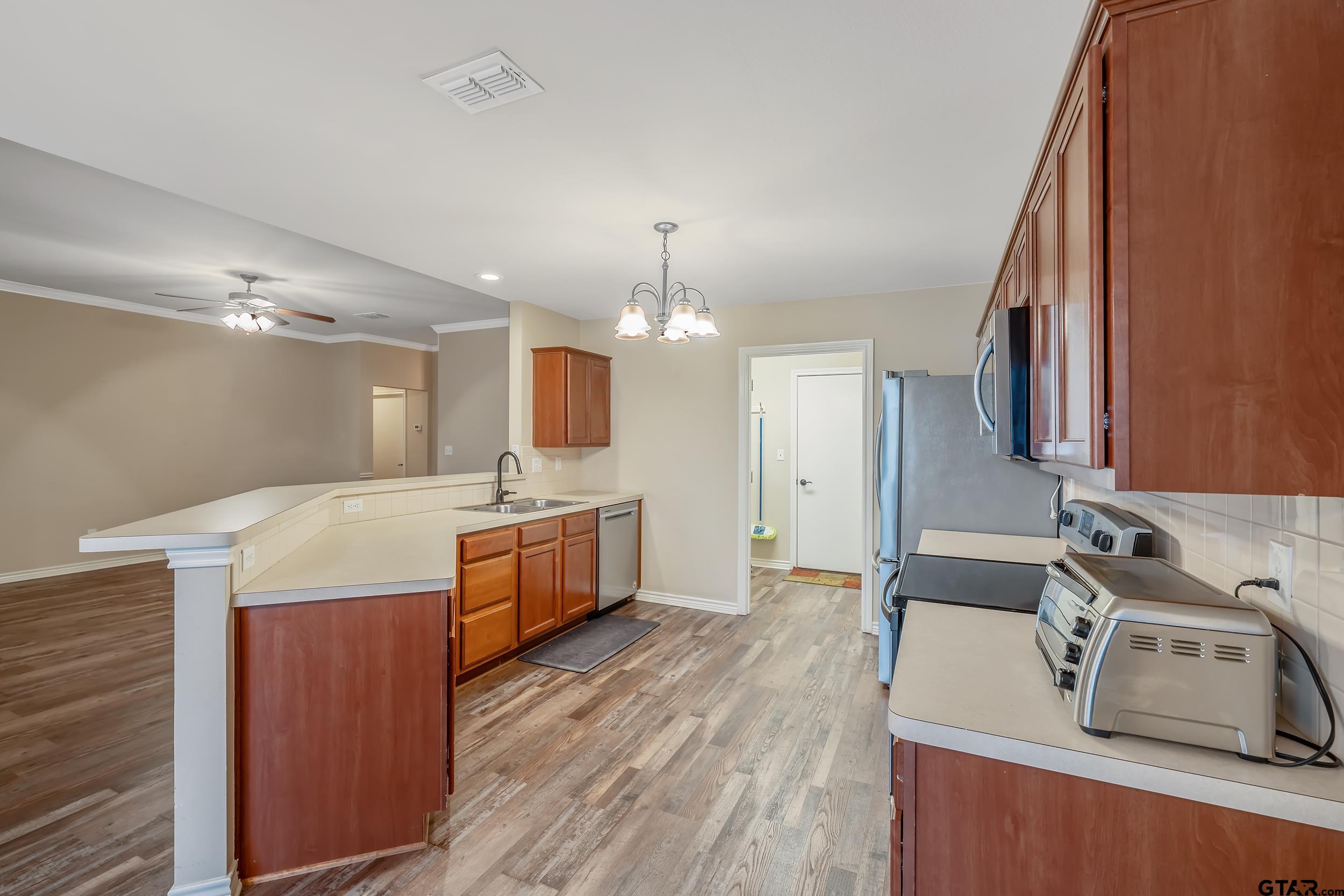 421 West Cumberland Road, Unit 205 Tyler, TX 75703 - Photo 5 of 24 a large kitchen with a lot of counter space and wooden floor