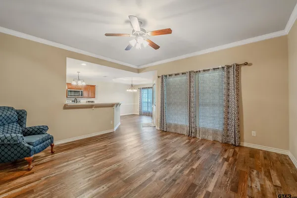 a view of a kitchen with wooden floor and a ceiling fan