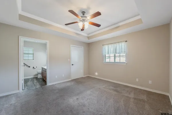 a view of an empty room with a ceiling fan and window