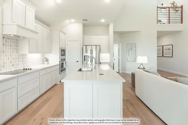 a kitchen with stainless steel appliances a sink a stove a refrigerator cabinets and a center island