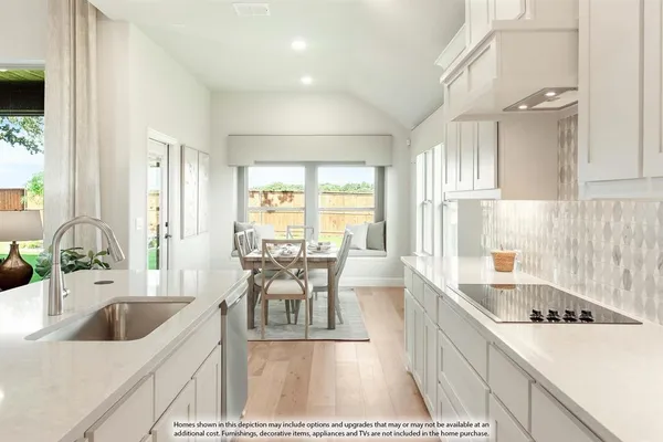 a large white kitchen with stainless steel appliances kitchen island granite countertop a refrigerator and a sink