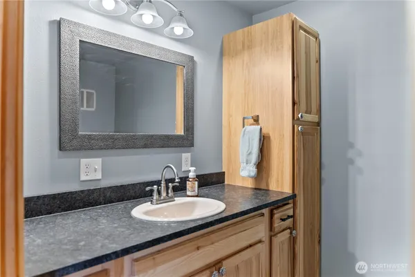 a bathroom with a granite countertop sink and a mirror