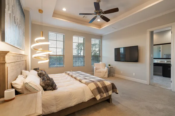 a bedroom with a bed flat screen tv and a large window