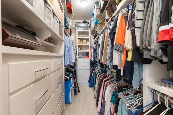 a view of walk in closet with clothes and shoes