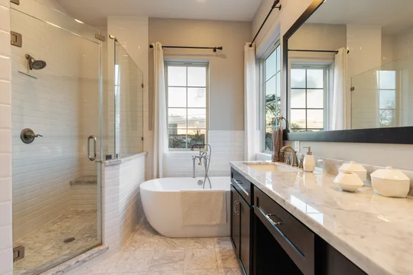 a bath room with a granite countertop sink mirror and a bathtub