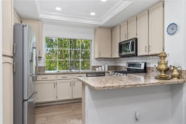 a kitchen with stainless steel appliances granite countertop a sink a stove and cabinets