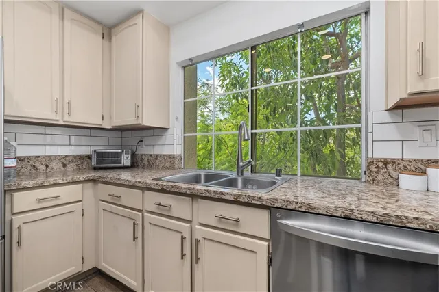 a kitchen with granite countertop white cabinets and a window