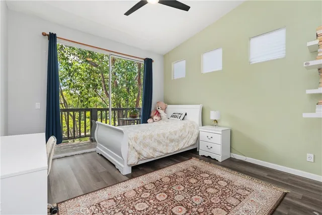 a bedroom with a bed a large window and mirror