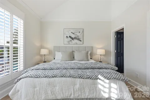 a bedroom with a large bed and a lamp