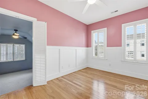 a view of empty room with window and wooden floor