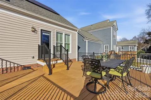 a view of a patio with table and chairs with wooden floor and fence