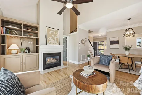 a living room with furniture a fireplace and a chandelier
