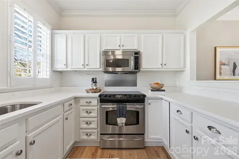 a kitchen with white cabinets and appliances