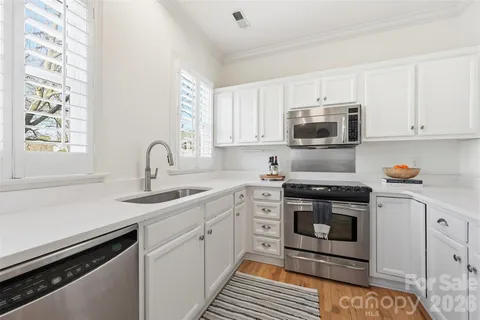 a kitchen with stainless steel appliances a sink stove and cabinets