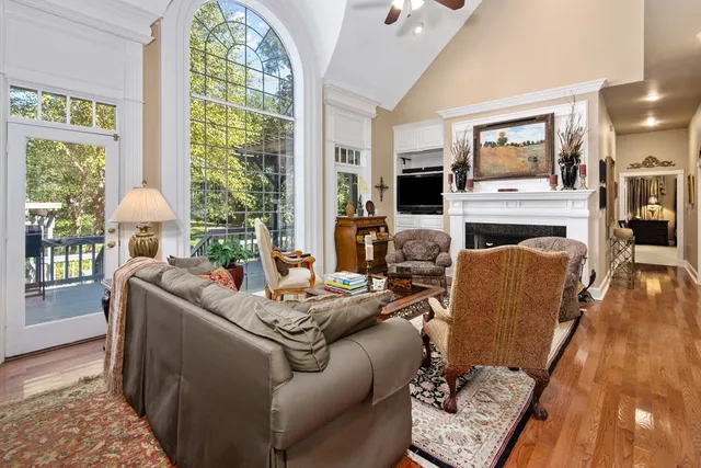 a living room with furniture large window and wooden floor