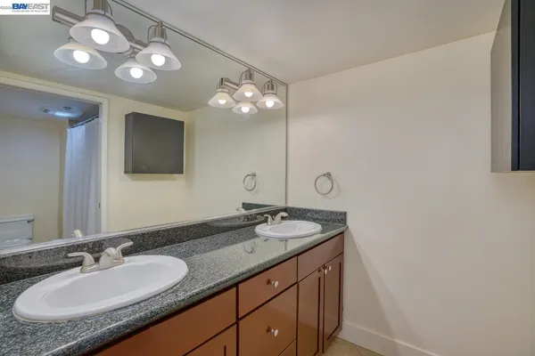 a bathroom with a granite countertop sink a large mirror and a shower