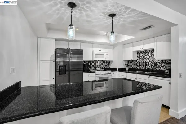 a kitchen with stainless steel appliances granite countertop a sink a counter top space cabinets and stainless steel appliances