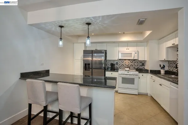 a kitchen with kitchen island a counter and chairs