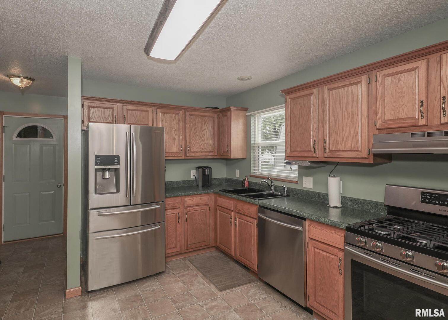 330 Sullivan Drive Colona, IL 61241 - Photo 13 of 31 a kitchen with stainless steel appliances granite countertop a refrigerator stove sink and cabinets