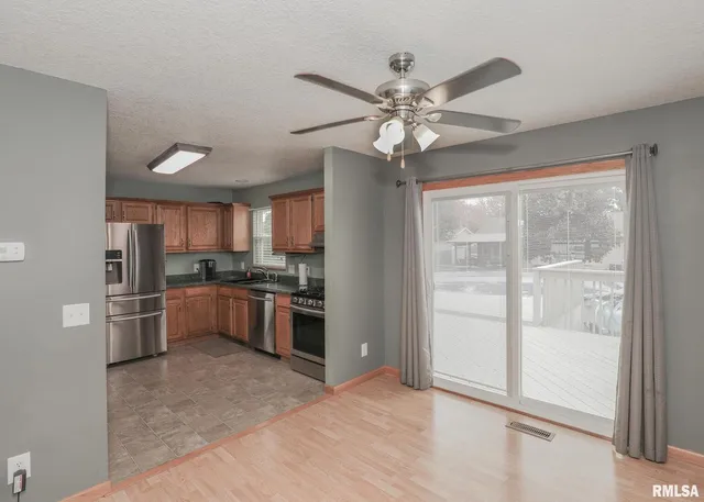 a view of an empty room with chandelier fan and fire place