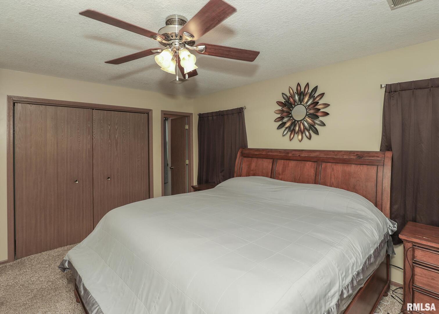 330 Sullivan Drive Colona, IL 61241 - Photo 23 of 31 a bedroom with a large bed and a chandelier