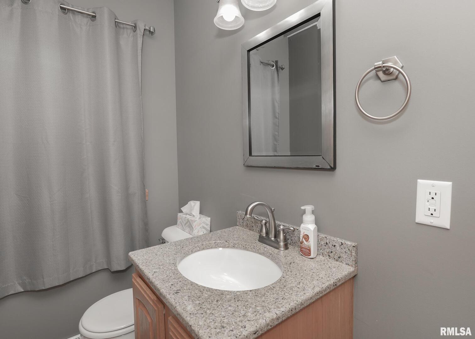 330 Sullivan Drive Colona, IL 61241 - Photo 25 of 31 a bathroom with a granite countertop sink and a mirror