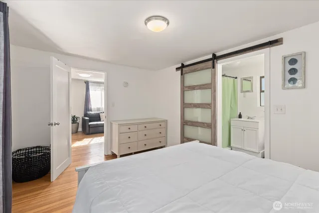 a bedroom with a bed and wooden floor