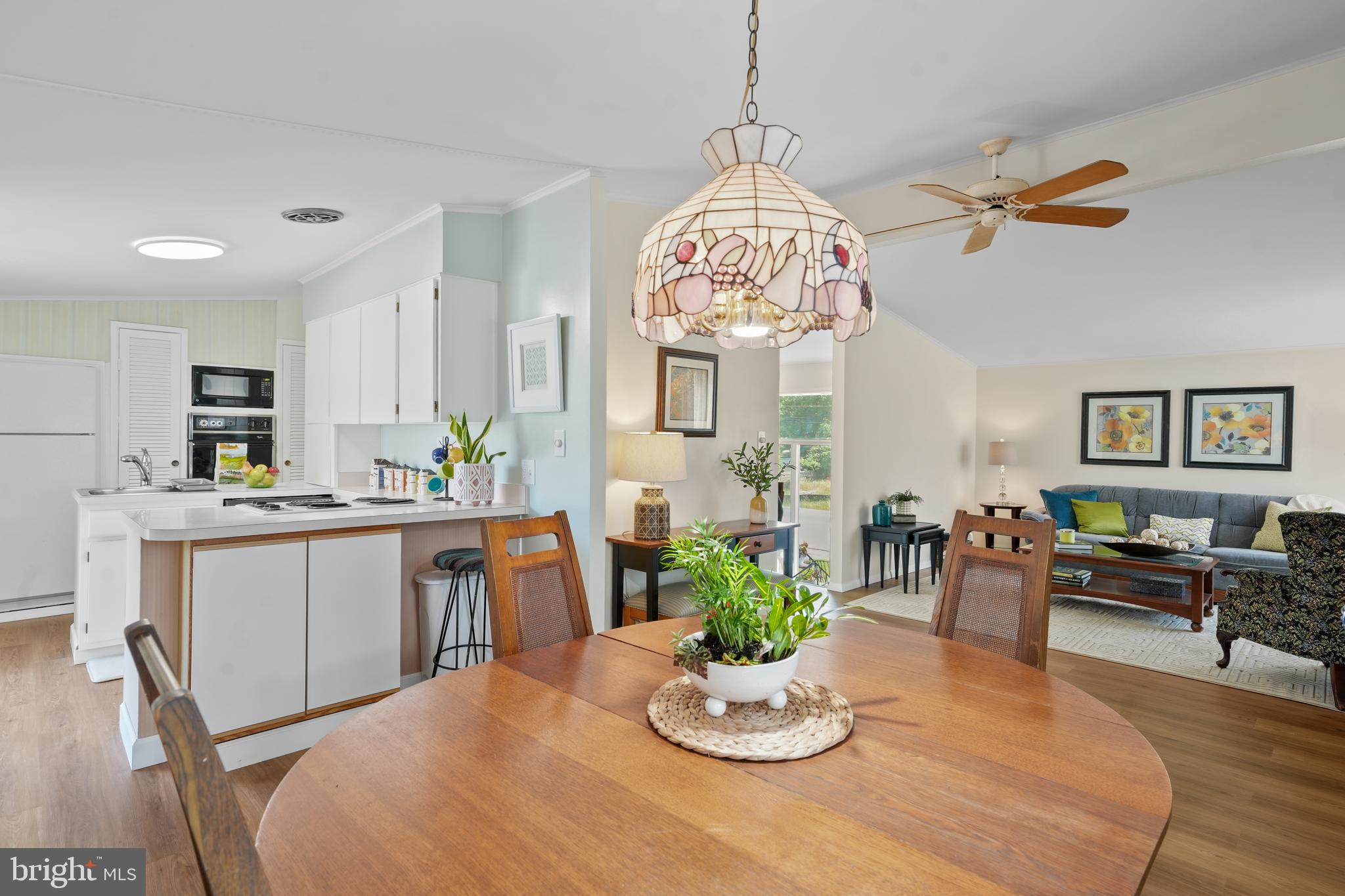8412 Winands Road Baltimore, MD 21208 - Photo 6 of 26 a kitchen with a dining table cabinets stainless steel appliances and wooden floor