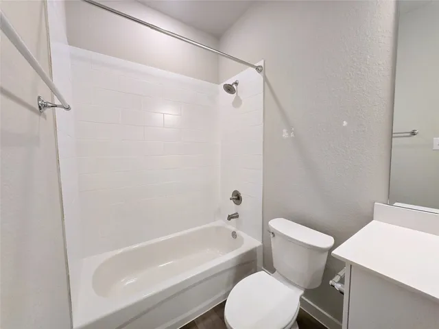 a white toilet and tub sitting next to a bathroom sink