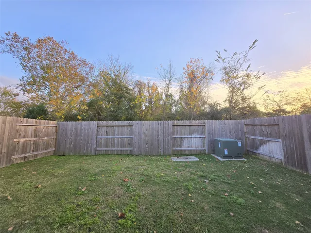 a view of a backyard with a potted plant and wooden fence