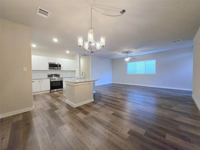 a view of a kitchen with a sink and dishwasher a refrigerator with wooden floor