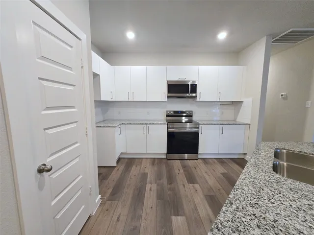 a kitchen with wooden floors and white appliances
