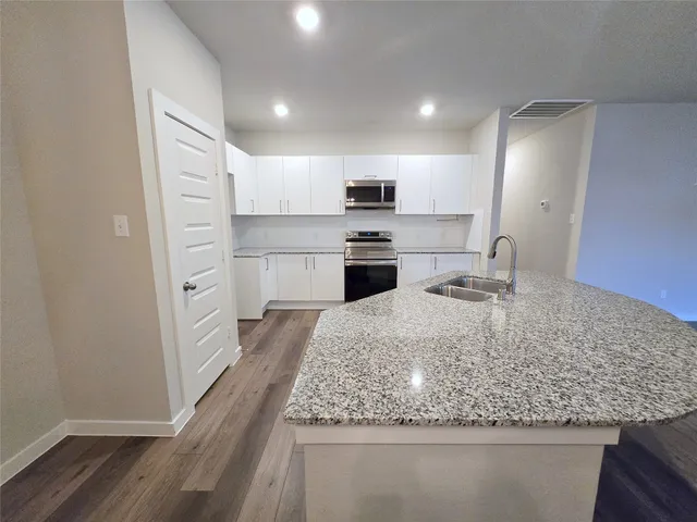 a kitchen with stainless steel appliances granite countertop a sink stove and refrigerator