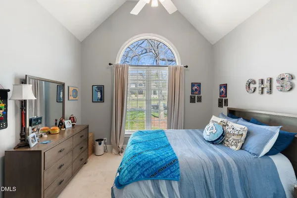 a bedroom with a large bed and chandelier