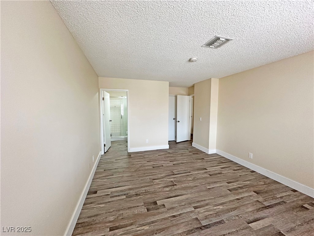 117 Boysenberry Lane Henderson, NV 89074 - Photo 16 of 22 Empty room featuring light wood-style flooring and a textured ceiling