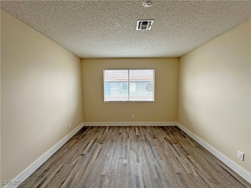 117 Boysenberry Lane Henderson, NV 89074 - Photo 18 of 22 Unfurnished room featuring wood finished floors and a textured ceiling