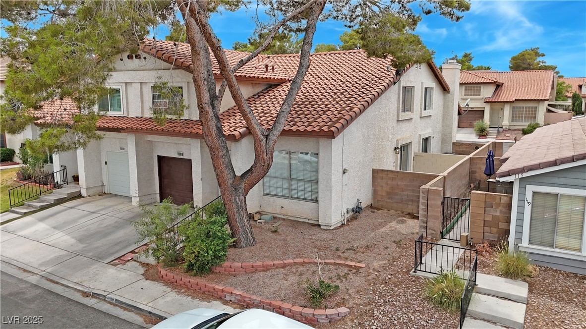 117 Boysenberry Lane Henderson, NV 89074 - Photo 2 of 22 Mediterranean / spanish-style home with stucco siding, a tile roof, an attached garage, driveway, and a residential view